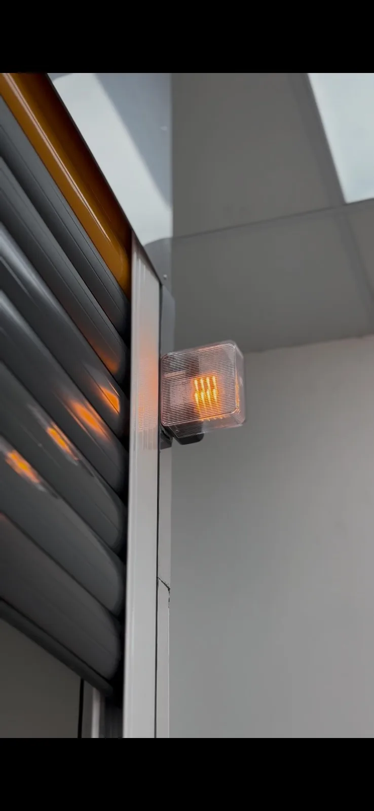 Amber emergency warning light flashing beside a shutter